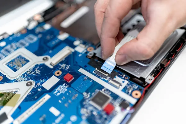 Close-up of a laptop motherboard being repaired